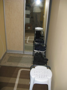 Entry with closet closed - our shoe rack (no one wears shoes in their homes) and the stool we got to sit on