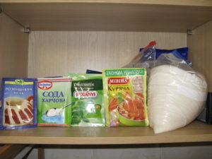This is my baking cabinet, bottom shelf. From left to right: baking powder, baking soda, basil, chicken broth mix, sugar. Behind the sugar is brown sugar and salt. Also I have a few other spices (oregano, cinnamon and cayenne).