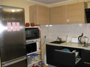 Kitchen - oven is on upper shelf and microwave is under it, refrigerator on the left, open drawer is our "dishwasher" next to the sink, stove is to the left of that with lots of storage