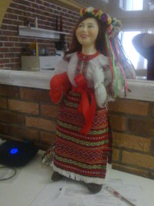 My doll standing by our mirror in the living room.