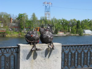 Cute critters sitting on the wall by the river.
